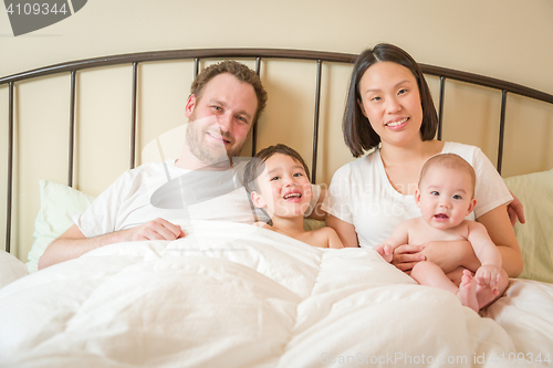 Image of Mixed Race Chinese and Caucasian Baby Boys Laying In Bed with Th