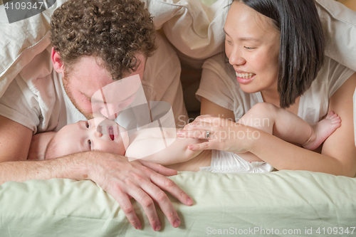 Image of Mixed Race Chinese and Caucasian Baby Boy Laying In Bed with His