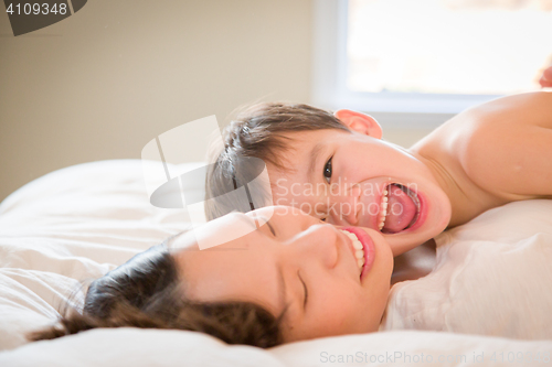 Image of Mixed Race Chinese and Caucasian Boy Laying In His Bed with His 