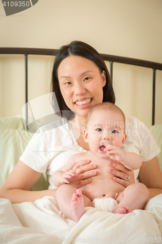 Image of Mixed Race Chinese and Caucasian Baby Boy Laying In Bed with His