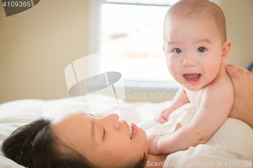 Image of Mixed Race Chinese and Caucasian Baby Boy Laying In Bed with His