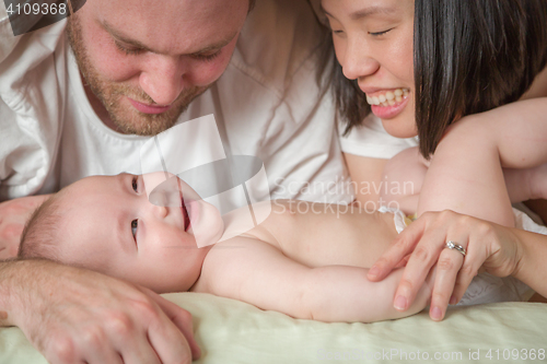 Image of Mixed Race Chinese and Caucasian Baby Boy Laying In Bed with His