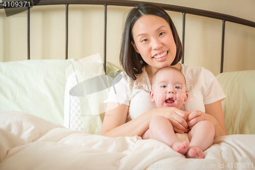 Image of Mixed Race Chinese and Caucasian Baby Boy Laying In Bed with His