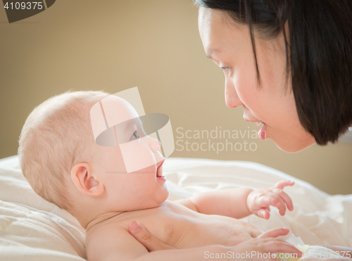 Image of Mixed Race Chinese and Caucasian Baby Boy Laying In Bed with His