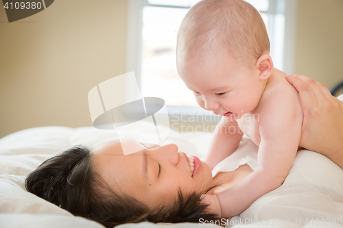 Image of Mixed Race Chinese and Caucasian Baby Boy Laying In Bed with His