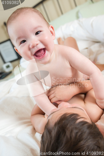 Image of Mixed Race Chinese and Caucasian Baby Brothers Having Fun Laying