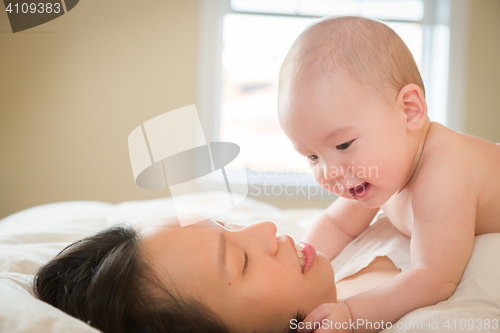 Image of Mixed Race Chinese and Caucasian Baby Boy Laying In Bed with His