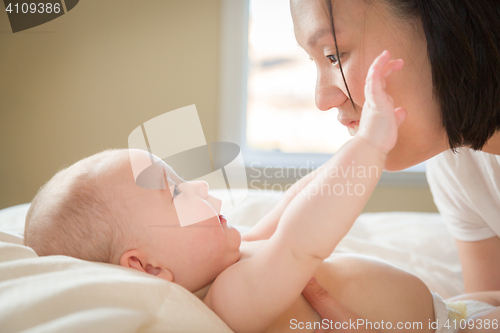 Image of Mixed Race Chinese and Caucasian Baby Boy Laying In Bed with His