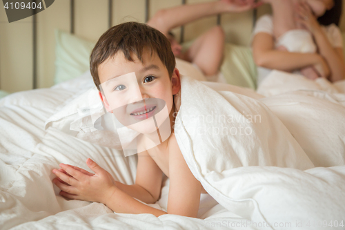 Image of Mixed Race Chinese and Caucasian Boy Laying In Bed with His Fath