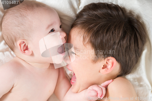 Image of Mixed Race Chinese and Caucasian Baby Brothers Having Fun Laying