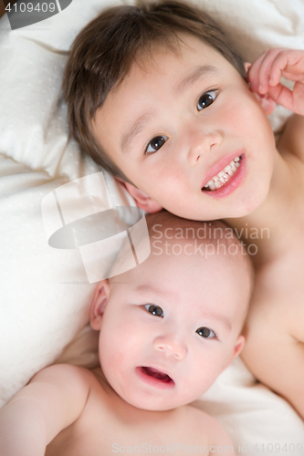 Image of Mixed Race Chinese and Caucasian Baby Brothers Having Fun Laying