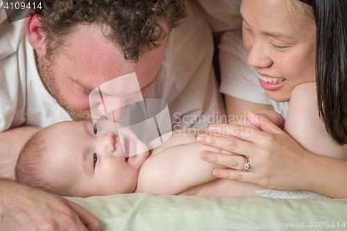 Image of Mixed Race Chinese and Caucasian Baby Boy Laying In Bed with His