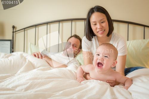 Image of Chinese and Caucasian Baby Boy Laying In Bed with His Parents