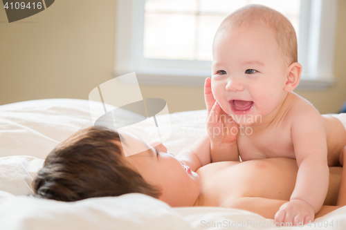 Image of Mixed Race Chinese and Caucasian Baby Brothers Having Fun Laying