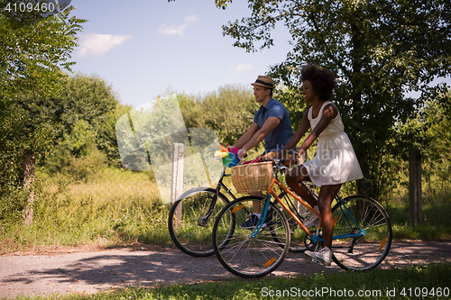 Image of Young multiethnic couple having a bike ride in nature