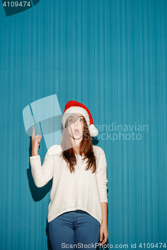 Image of Surprised christmas girl wearing a santa hat