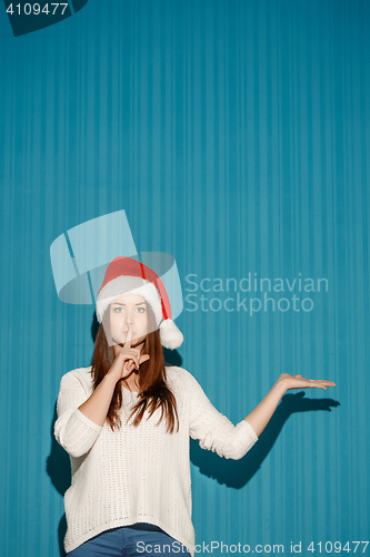 Image of Surprised christmas girl wearing a santa hat