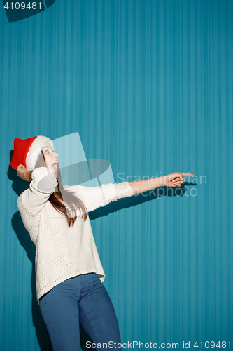 Image of Surprised christmas girl wearing a santa hat