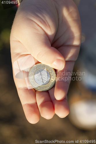 Image of coin in the hands of a child