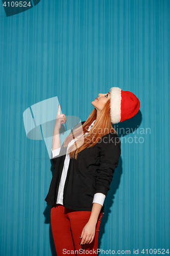 Image of Surprised christmas girl wearing a santa hat