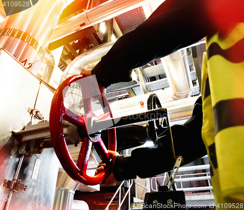 Image of factory worker turning valve