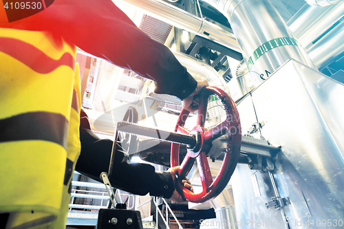 Image of factory worker turning valve