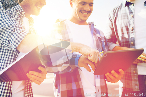 Image of group of smiling builders with tablet pc outdoors