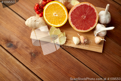 Image of citrus fruits, ginger and garlic on wood