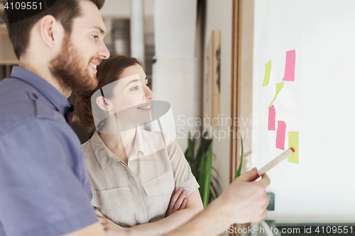 Image of creative team with stickers on glass at office