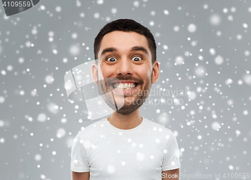 Image of man with funny face over snow background