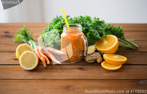 Image of glass jug of carrot juice, fruits and vegetables