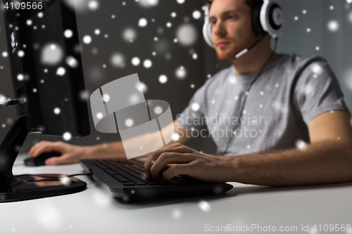 Image of man with headset playing computer video game