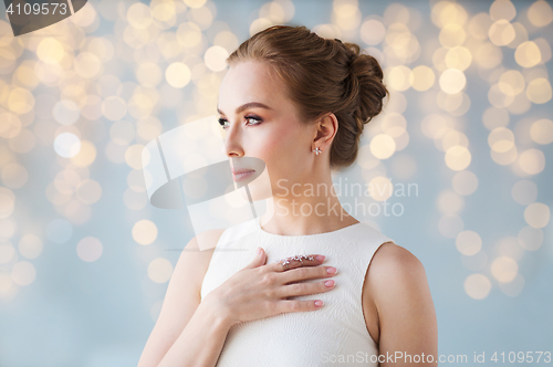 Image of smiling woman in white dress with diamond jewelry