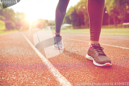 Image of close up of woman feet running on track from back