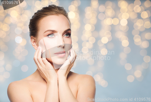 Image of beautiful young woman touching her face