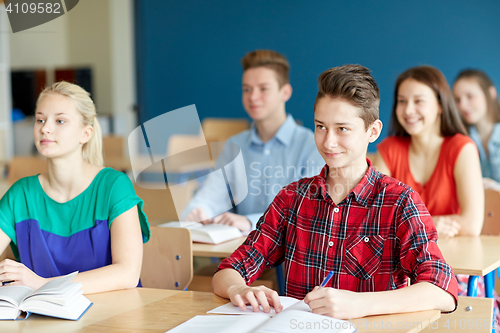 Image of group of students with notebooks at school lesson