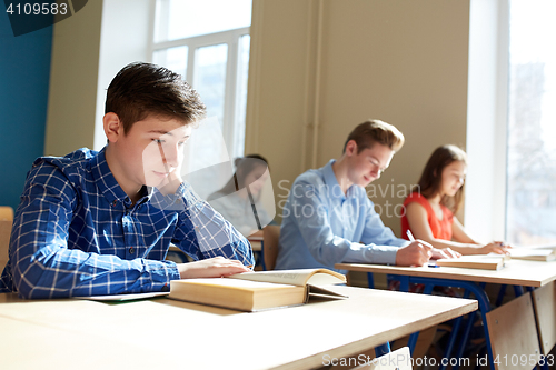 Image of group of students with books writing school test