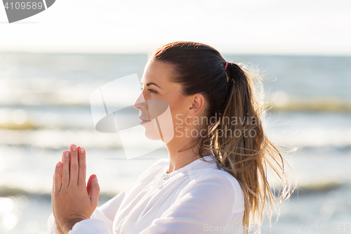 Image of woman making yoga on summer beach