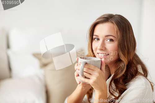 Image of happy woman with cup of tea or coffee at home