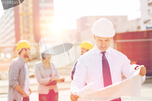 Image of group of builders with tablet pc and blueprint