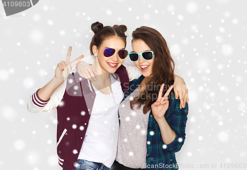 Image of smiling teenage girls in sunglasses showing peace