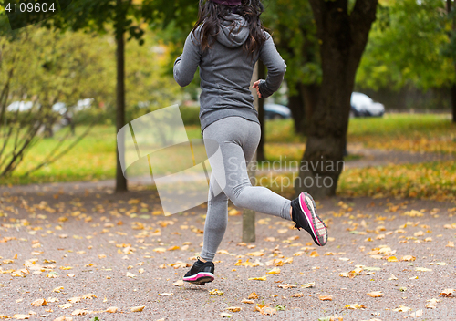 Image of close up of young woman running in autumn park