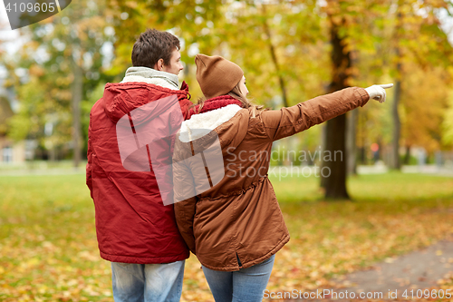 Image of happy young couple walking in autumn park