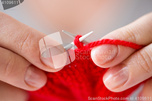 Image of close up of hands knitting with needles and yarn