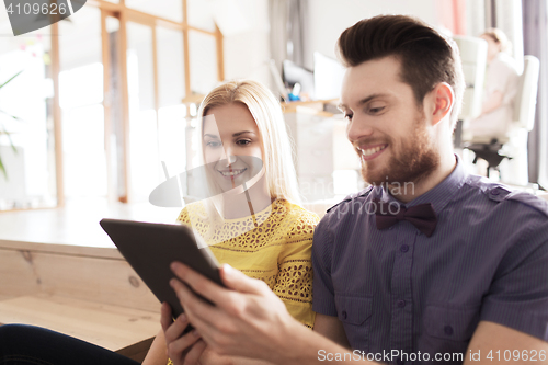 Image of happy creative team with tablet pc in office