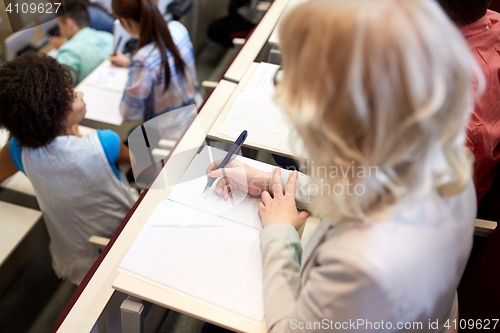 Image of student writing to notebook at exam or lecture