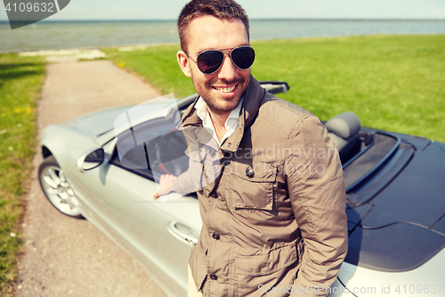 Image of happy man near cabriolet car outdoors