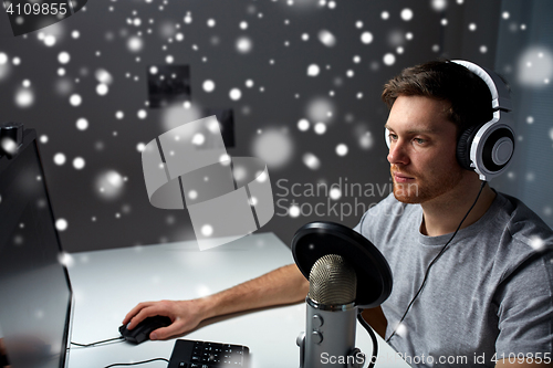 Image of man in headset playing computer video game at home