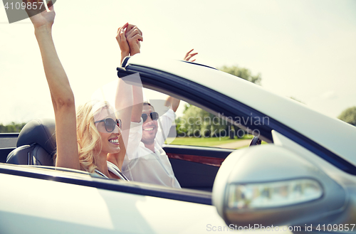 Image of happy man and woman driving in cabriolet car