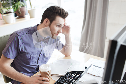 Image of creative male worker with computer drinking coffee